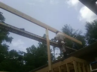 Carpenter setting a ridge beam over a new addition frame — Ice Dam Removal by Roofing Brothers in Shelton