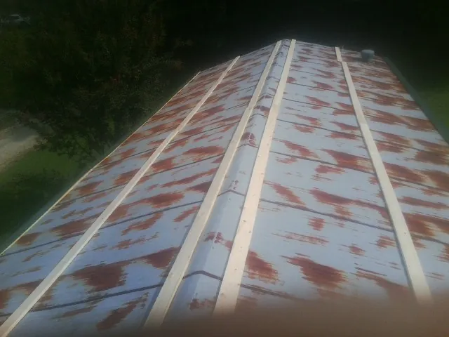 Rusted metal roof panels with new wood purlins before replacement — Storm Damage Roof Repair in Shelton by Roofing Brothers